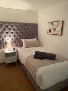 a bedroom with a large bed with a purple headboard at Apto a 2 minutos de Parque la Valvanera in Bogotá