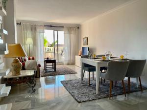 sala de estar con mesa y sillas y sala de estar. en Apartamento con vistas al mar en Reserva de Marbella, en Marbella