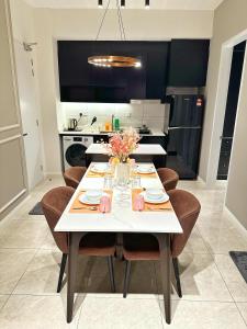 Axon Residence Bukit Bintang By TR Suites في كوالالمبور: غرفة طعام مع طاولة بيضاء وكراسي