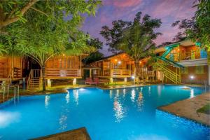 a swimming pool in front of a house at Woodgreens Heritage Resorts in Kannur