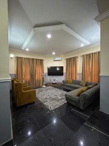 a living room with couches and a flat screen tv at Sillich Homes - 4 Bedroom Duplex in Lokogoma in Abuja