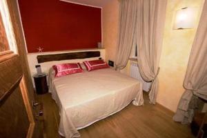 モンテロッソ・アル・マーレにあるアフィタカメレ ダ チェサレのベッドルーム1室(赤い枕2つ付きのベッド1台付)