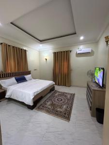 a bedroom with a bed and a flat screen tv at Sillich Homes - 4 Bedroom Duplex in Lokogoma in Abuja