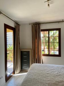 プラヤ・デ・ファニャベにあるPueblo Canario Apartment for 6 persons!のベッドルーム1室(ベッド1台、大きな窓2つ付)
