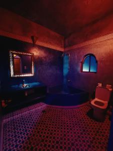 a purple bathroom with a tub and a toilet at Mask Off Artel in Essaouira