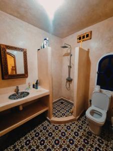 a bathroom with a sink and a toilet and a mirror at Mask Off Artel in Essaouira