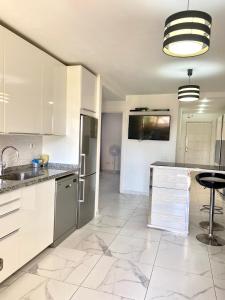 プラヤ・デ・ファニャベにあるPueblo Canario Apartment for 6 persons!のキッチン(白いキャビネット、カウンタートップ付)