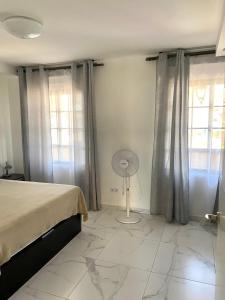 プラヤ・デ・ファニャベにあるPueblo Canario Apartment for 6 persons!のベッドルーム1室(ベッド1台、窓2つ、ファン付)が備わります。