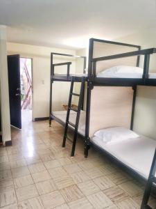 a room with three bunk beds and a hallway at Roof Hostel in Cali