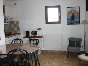 a kitchen with a table and chairs and a microwave at Studio Albiez-Montrond, 1 pièce, 4 personnes - FR-1-618-22 in Albiez-Montrond