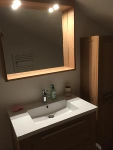 a bathroom with a white sink and a mirror at Chalet 1829 in Sainte-Foy-Tarentaise