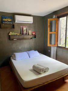een bed met twee handdoeken in een kamer bij Salty Enthusiasts Share House & Villas in Santa Teresa Beach