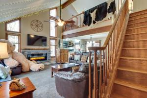 a living room with a staircase and a living room with a cow rug at Pocono Mountains Retreat with Pool Table and Hot Tub! in Albrightsville