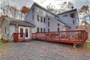 a large white house with a large deck at Pocono Mountains Retreat with Pool Table and Hot Tub! in Albrightsville