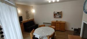 a small living room with a table and a chair at Cauterets centre - Résidence Le marcadau 1 in Cauterets