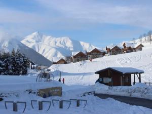 una montaña cubierta de nieve con un lodge en el fondo en Studio Albiez-Montrond, 1 pièce, 4 personnes - FR-1-618-37, en Albiez-Montrond