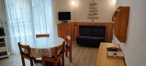 a small living room with a table and a chair at Cauterets centre - Résidence Le marcadau 1 in Cauterets +1 photo