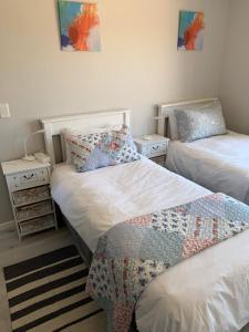 une chambre avec deux lits et deux tables de nuit dans l'établissement Coastal & Country Living in Langebaan, à Langebaan