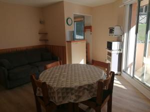 a living room with a table and a couch at Cauterets centre - Résidence Le marcadau 1 in Cauterets