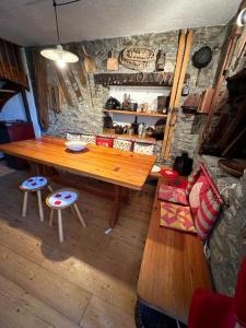 a wooden table and chairs in a room at Tipica casa di montagna nel borgo del Verrand a Courmayeur in Pré-Saint-Didier