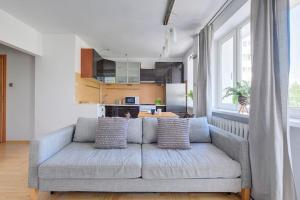a living room with a couch and a kitchen at Palace View near Złote Tarasy Apartment in City Center in Warsaw +6 photos
