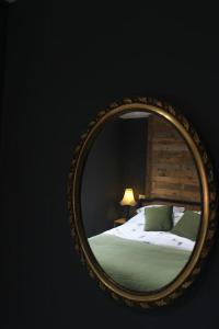un miroir reflétant un lit avec des draps verts et une lampe dans l'établissement Brighton City Flat Perfect for long stays, à Brighton et Hove