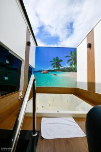 a bath tub in a room with a view of the ocean at MOTEL LA FOLIA in Ribeirão Preto