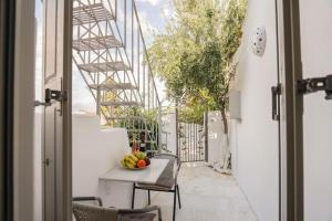 Un balcón con una mesa con fruta. en Villa Artemis Cycladic Charmed ! en Athens