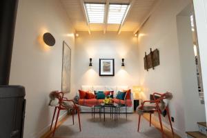 a living room with a couch and a table and chairs at Villa Artemis Cycladic Charmed ! in Athens