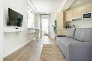 ein Wohnzimmer mit einem Sofa und einem Flachbild-TV in der Unterkunft NEW Functional and Sunny Apartment near La Union by REMS in Málaga