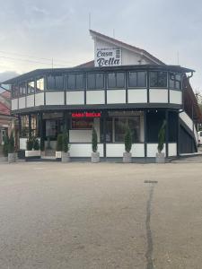 Ocna-Mureşului的住宿－CASA BELLA，前面有盆栽植物的建筑前方的商店