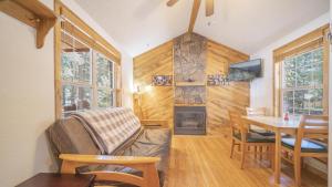 sala de estar con sofá, mesa y chimenea en The Iris Cabin #1 at Blue Spruce RV Park & Cabins, en Tuckerville