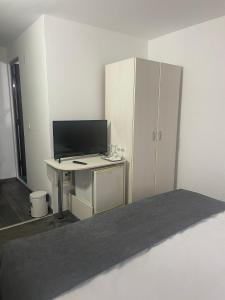 a room with a desk with a computer and a cabinet at CASA BELLA in Ocna-Mureşului