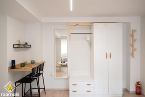 Habitación con armario blanco y mesa. en roomaki - new & stylish studio in the center with parking en Chalkida