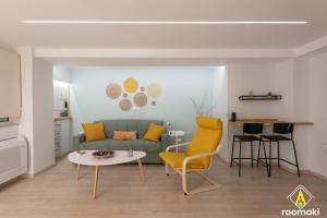 a living room with a green couch and yellow chairs at roomaki - new & stylish studio in the center with parking in Chalkida