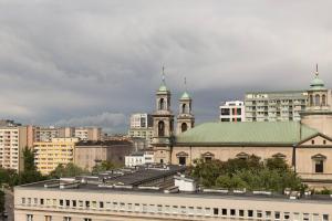 een groep gebouwen in een stad met een bewolkte lucht bij Emilii Plater 55 Center 2 bedrooms Living room balcony in Warschau