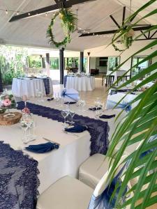 une chambre avec des tables, des chaises et des verres à vin dans l'établissement Rivland Resort, à Païta