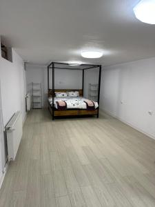 a bedroom with a bed and a wooden floor at Airport Confort House in Otopeni