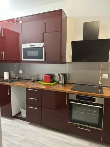 uma cozinha com armários roxos e um balcão com um fogão em Airport Confort House em Otopeni