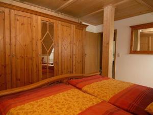 a bedroom with a bed and wooden cabinets at Am-Turm in Mellrichstadt