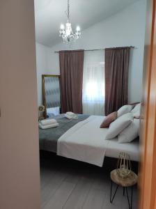 a bedroom with a large white bed with a chandelier at Apartman Debora sa privatnim bazenom in Pula +69 photos
