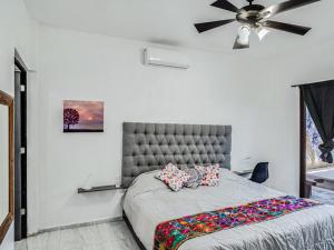 a bedroom with a large bed with a ceiling fan at Casa Emma in Holbox Island