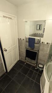 een badkamer met een toilet en een blauwe stoel. bij Belfast Waterworks Townhouse in Belfast
