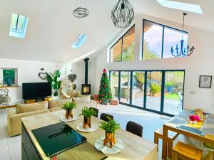 a living room with a christmas tree in the middle at New build Luxurious PALMA VILLA IN CORNWALL! 4miles EDEN PROJECT, 4 miles Beach & Harbour! Open plan, One level Living area Ground floor, Private location, Encllosed Garden, Underfloor Heating, Coffee Machine,near WALKING-CYCLING PATH in St Austell