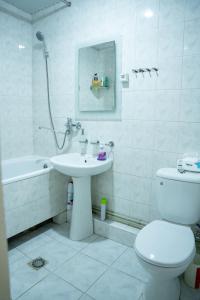 a white bathroom with a sink and a toilet at Ners Guest House in Gyumri