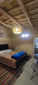 a bedroom with a large bed and a chandelier at Maroc des Merveilles - Chez L'habitant in Kalaat MGouna