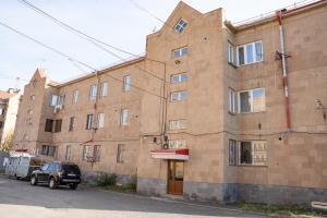 a large brick building with a truck parked in front of it at Ners Guest House in Gyumri