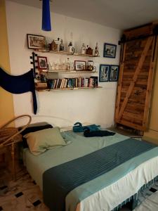 ein Schlafzimmer mit einem Bett und Regalen an der Wand in der Unterkunft L'artisan in Harqalah