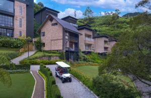 um carrinho de golfe estacionado em frente a uma casa em The Golden Ridge Hotel em Nuwara Eliya