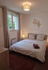 a bedroom with a bed with a pair of shoes on it at App 2 - T2 Lumineux et Jardin Hyper-Centre 5min de la gare in Évreux